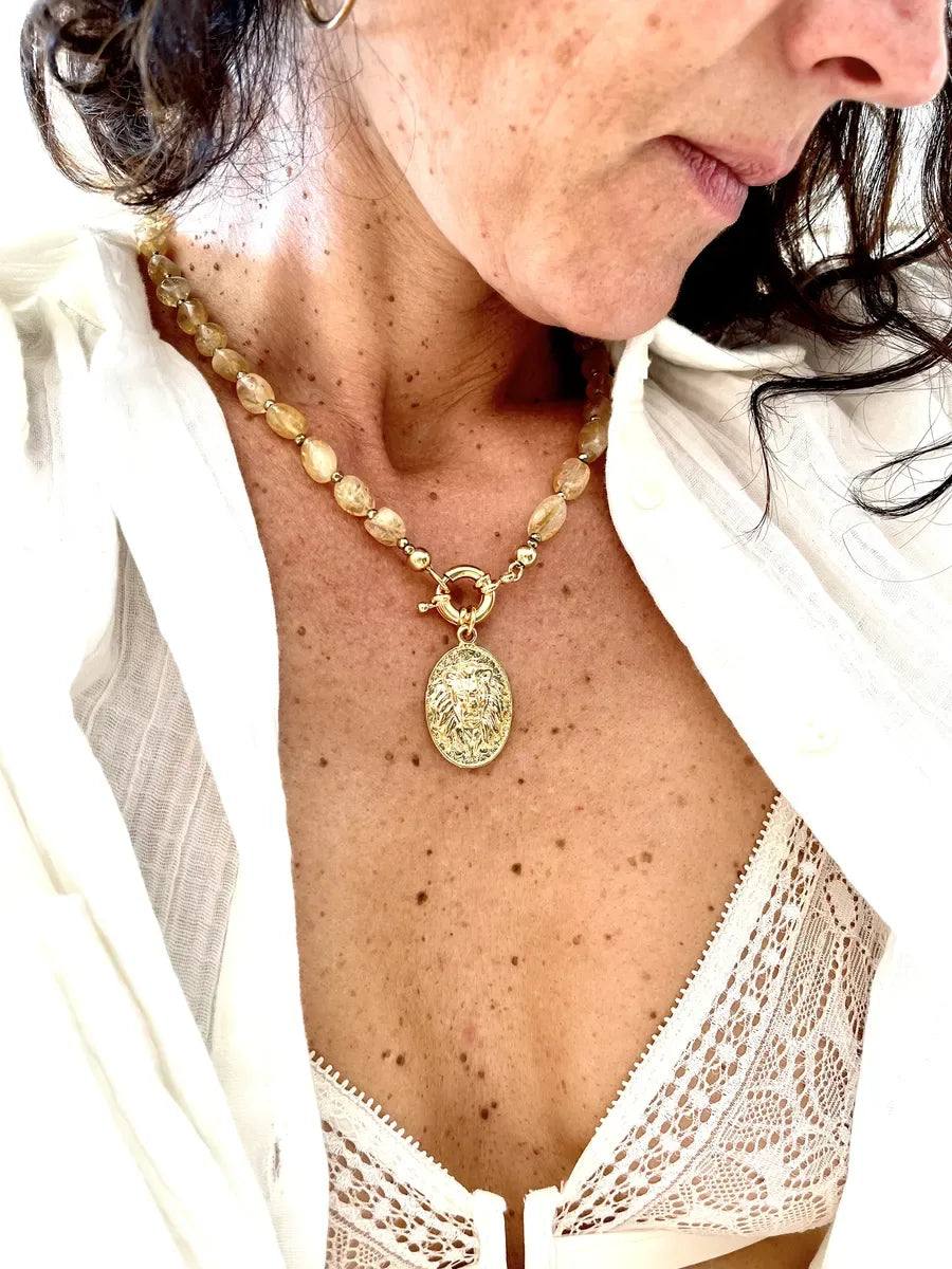 collier saba citrine est un collier ras de cou avec des pierres de citrine et un fermoir bouée ainsi qu'un médaillon plaqué or tête de lion ancien